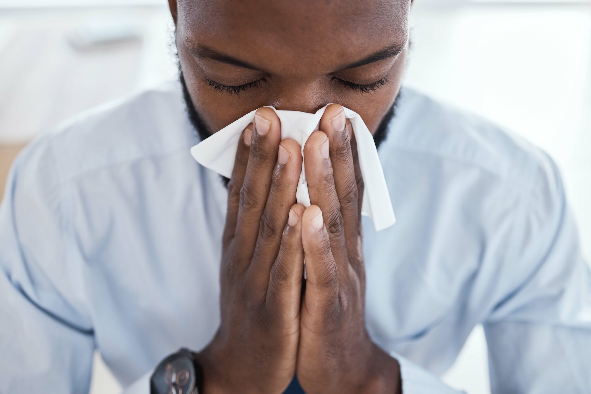 Black man, tissue and blowing nose in the office with allergies, sickness and virus. Business emplo